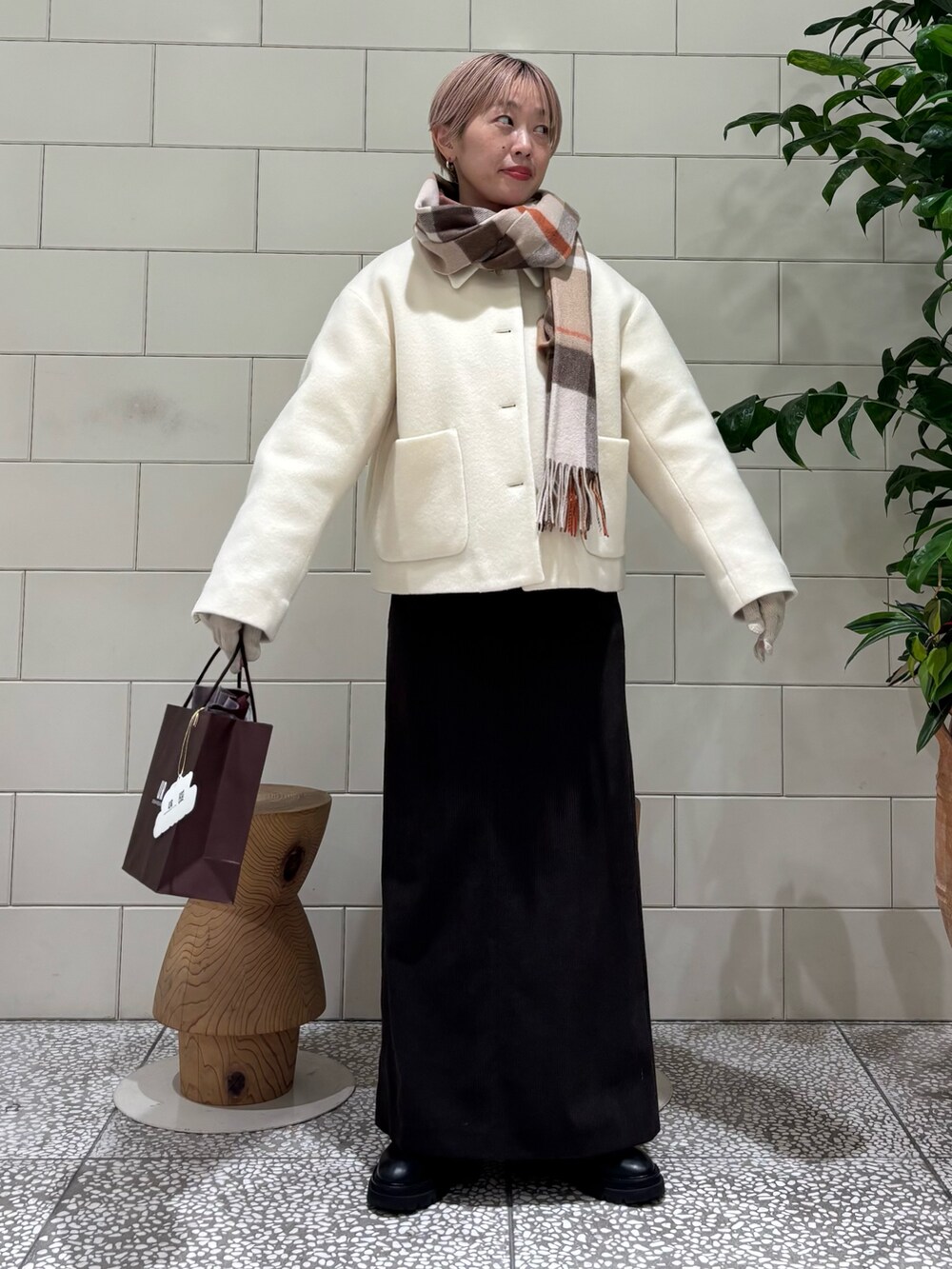 ホワイト系のその他アウター、グレー系のスカート、ブラウン系のストール/ショールを着用したレディースの冬コーディネートの2枚目の写真