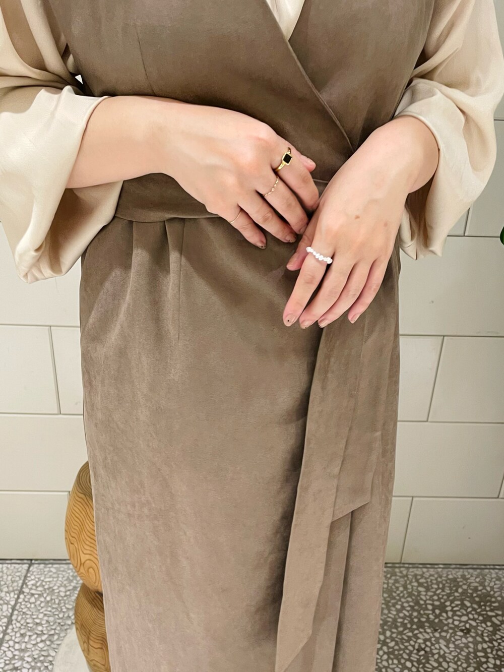 ブラウン系のワンピース、ホワイト系のシャツ/ブラウス、ブラック系のブーツを着用したレディースの秋コーディネートの3枚目の写真