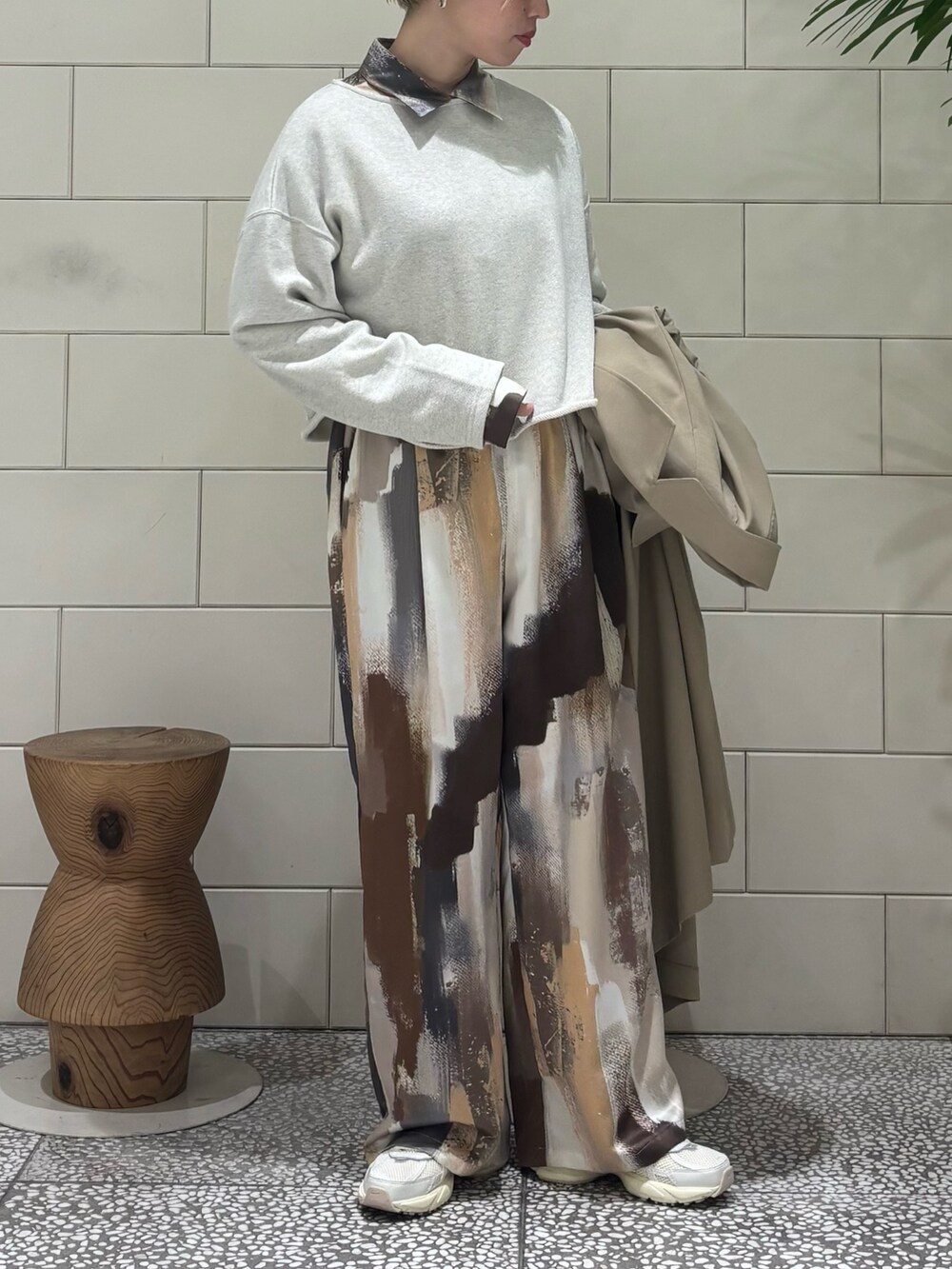 ベージュ系のトレンチコート、オレンジ系のシャツ/ブラウス、ベージュ系のスウェットを着用したレディースの冬コーディネートの2枚目の写真