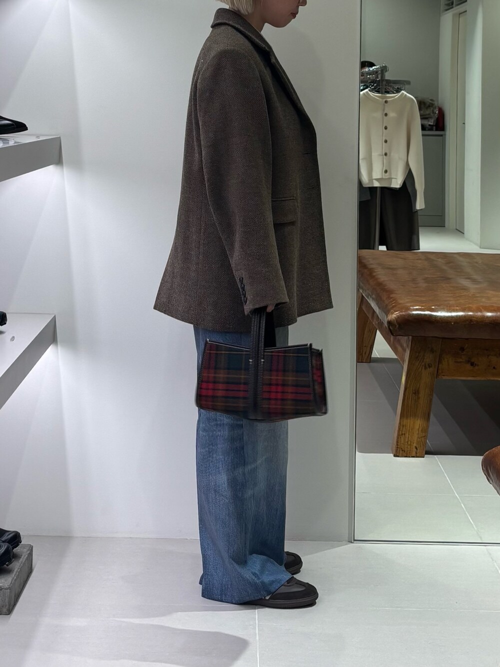 グリーン系のその他アウター、レッド系のニット/セーター、ブルー系のその他パンツを着用したレディースの秋コーディネートの2枚目の写真