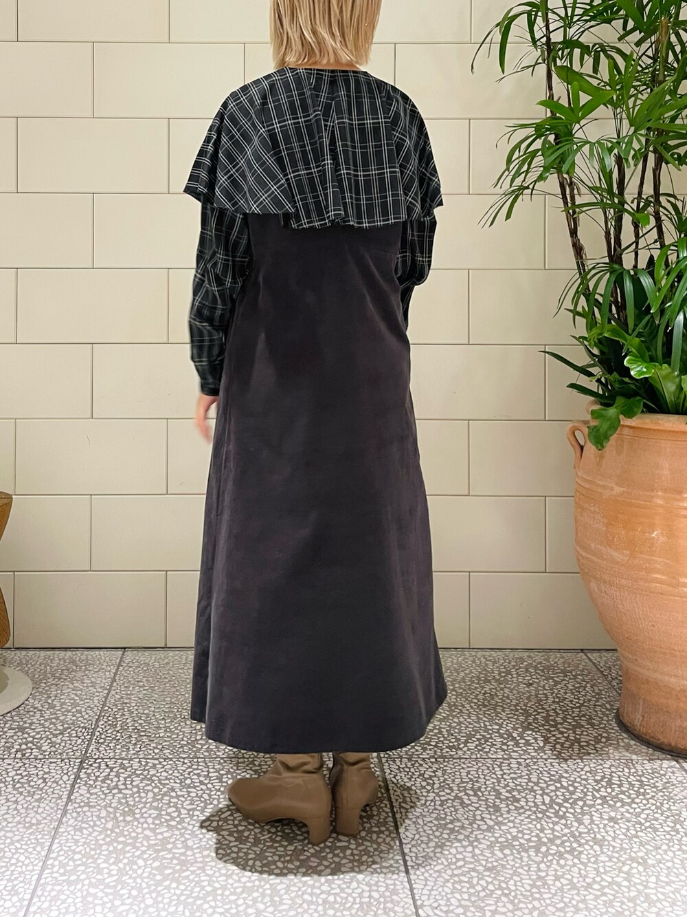 グレー系のワンピース、ブラック系のシャツ/ブラウス、ベージュ系のブーツを着用したレディースの冬コーディネートの3枚目の写真