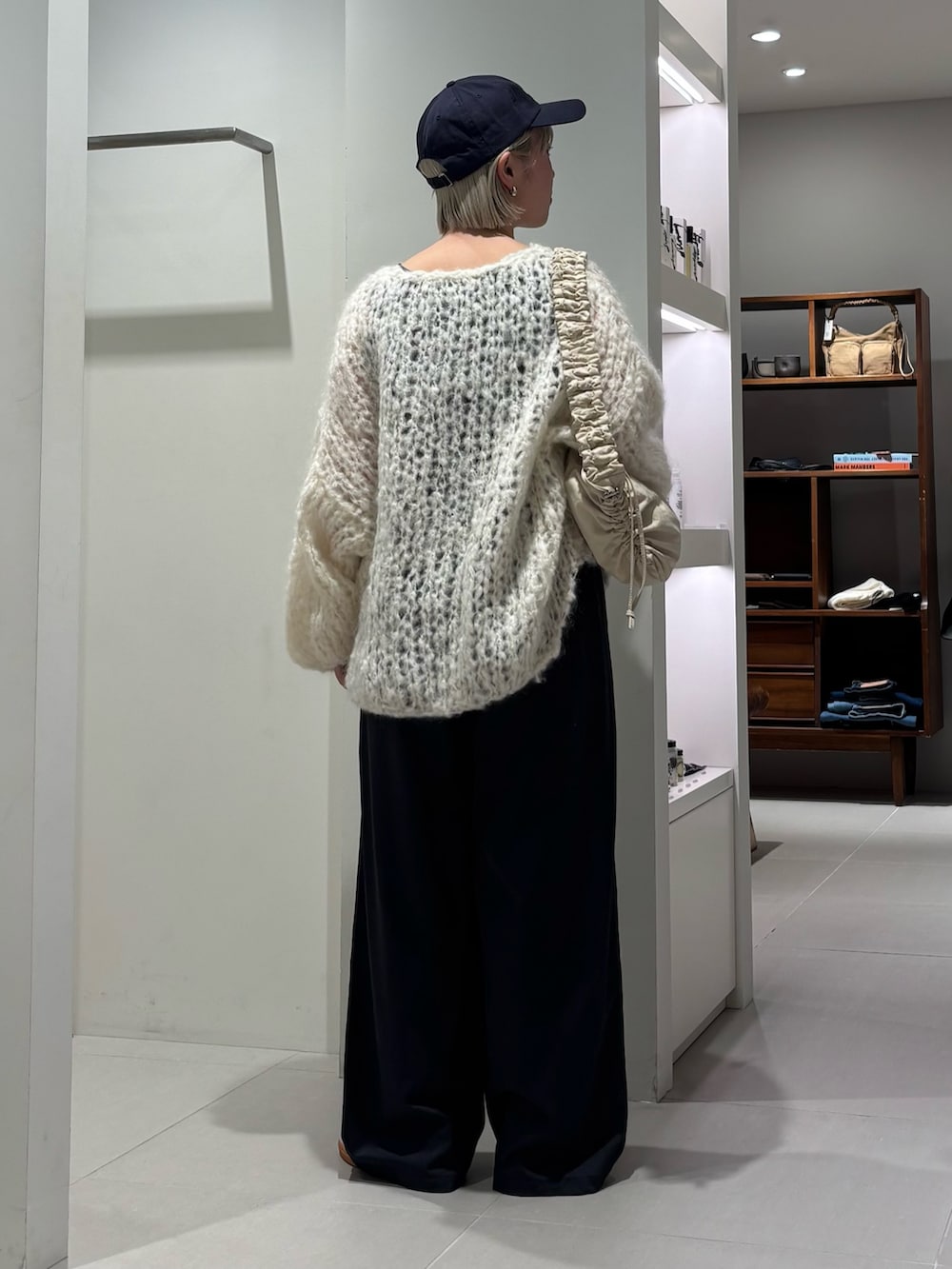 ホワイト系のニット/セーター、ホワイト系のショルダーバッグ、グレー系のその他パンツを着用したレディースの秋コーディネートの3枚目の写真