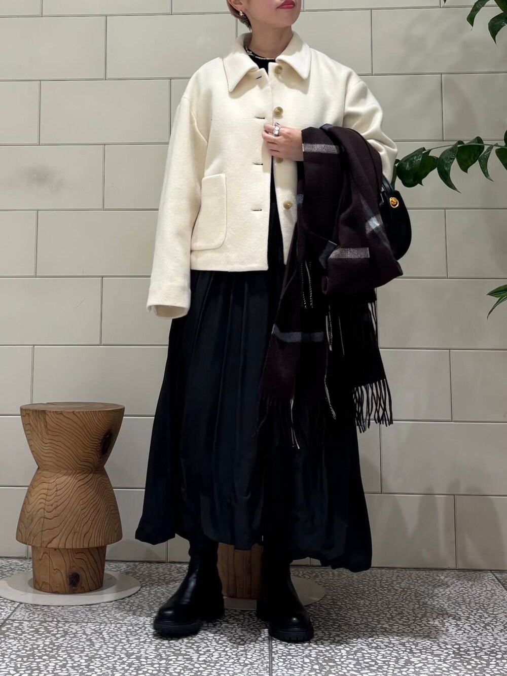 ブラック系のブーツ、ホワイト系のその他アウター、ブラック系のワンピースを着用したレディースの冬コーディネートの5枚目の写真