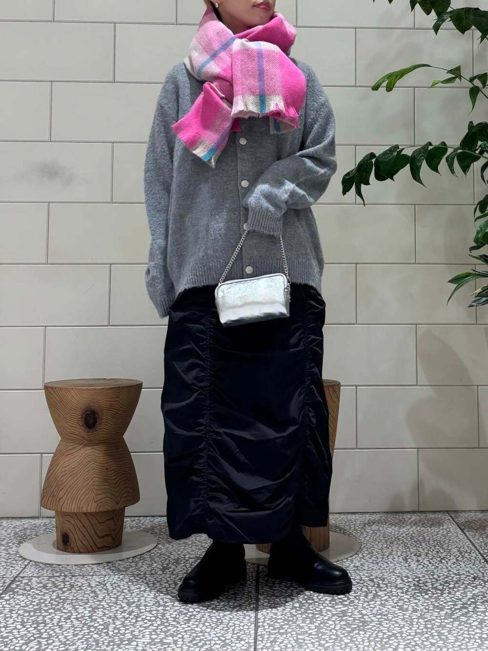 ブラック系のスカート、ブラック系のブーツ、グレー系のカーディガン/ボレロを着用したレディースの秋コーディネートの3枚目の写真