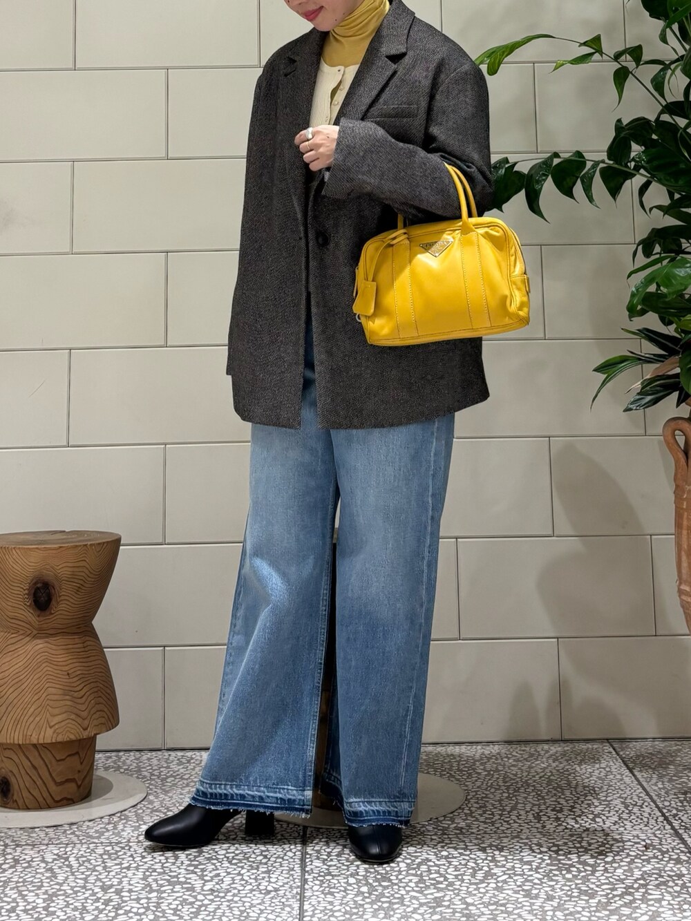 イエロー系のTシャツ/カットソー、ホワイト系のニット/セーター、ブラック系のその他アウターを着用したレディースの秋コーディネートの2枚目の写真