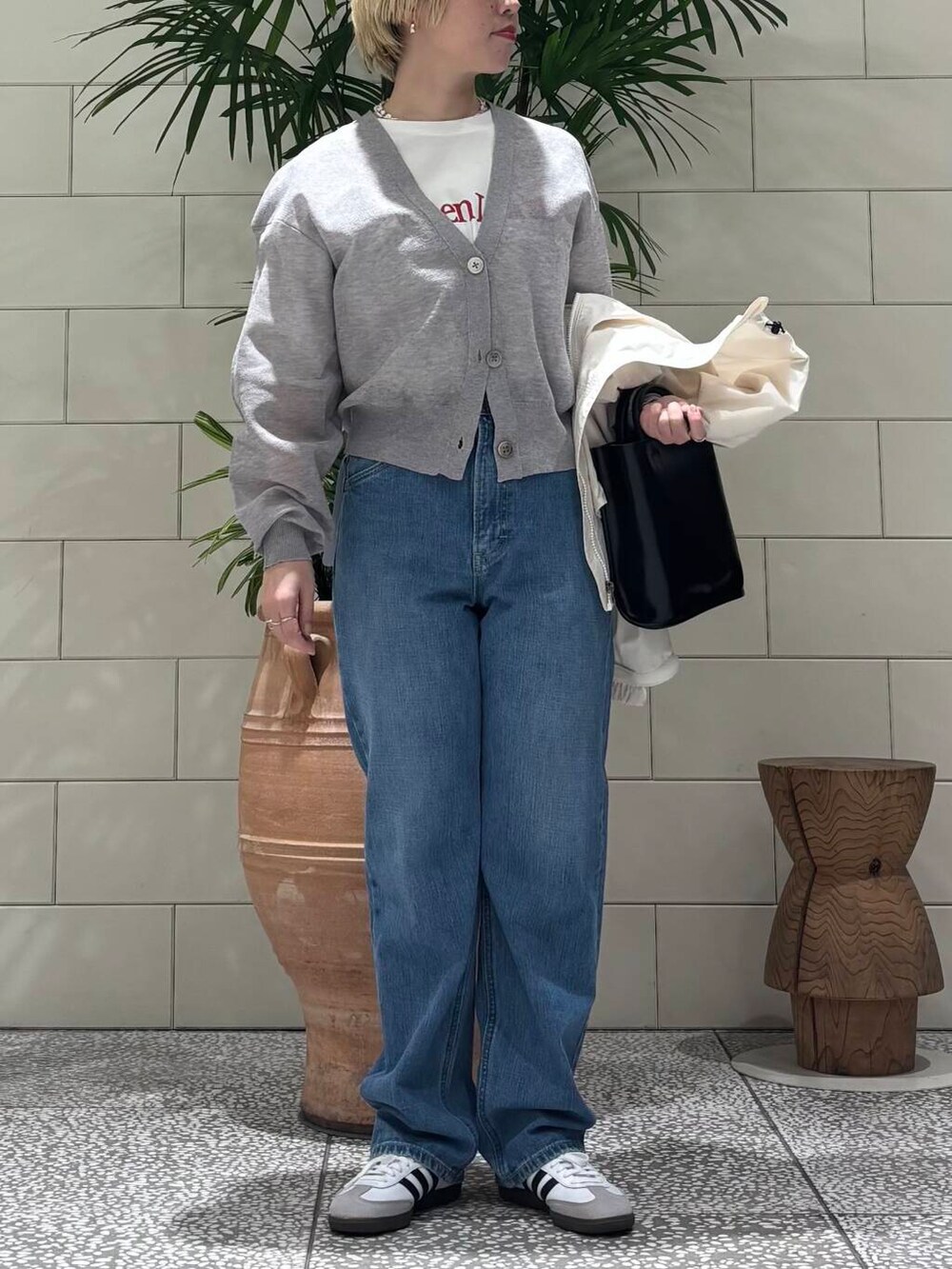 グレー系のカーディガン/ボレロ、ホワイト系のスニーカー、その他のTシャツ/カットソーを着用したレディースの冬コーディネートの2枚目の写真