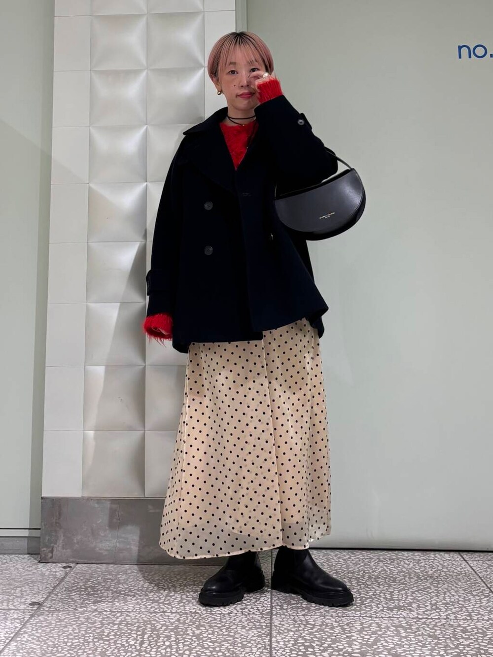 ブルー系のピーコート、レッド系のカーディガン/ボレロ、ベージュ系のスカートを着用したレディースの冬コーディネートの5枚目の写真