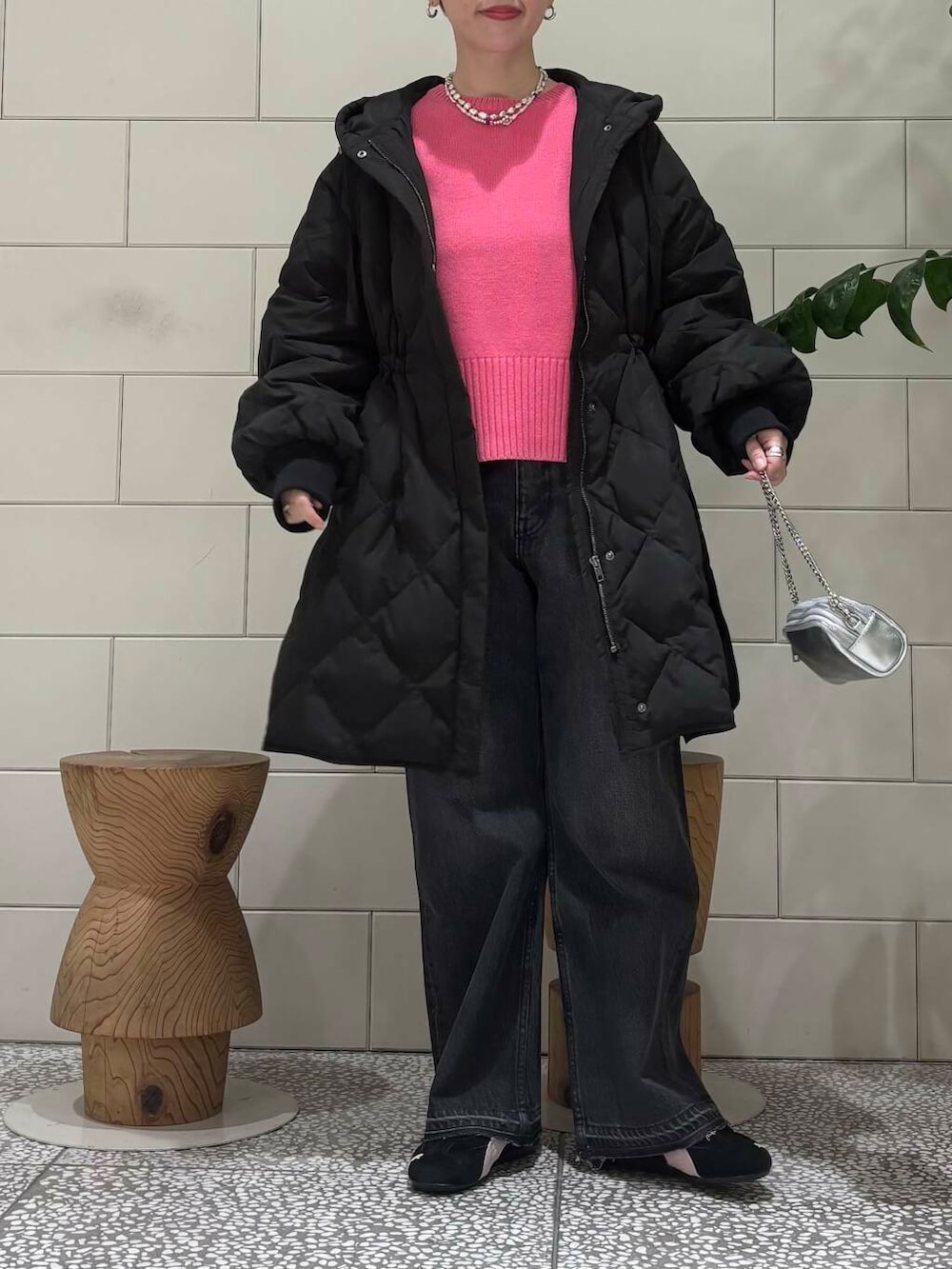 ブラック系のデニムパンツ、ピンク系のニット/セーター、シルバー系のショルダーバッグを着用したレディースの冬コーディネートの4枚目の写真