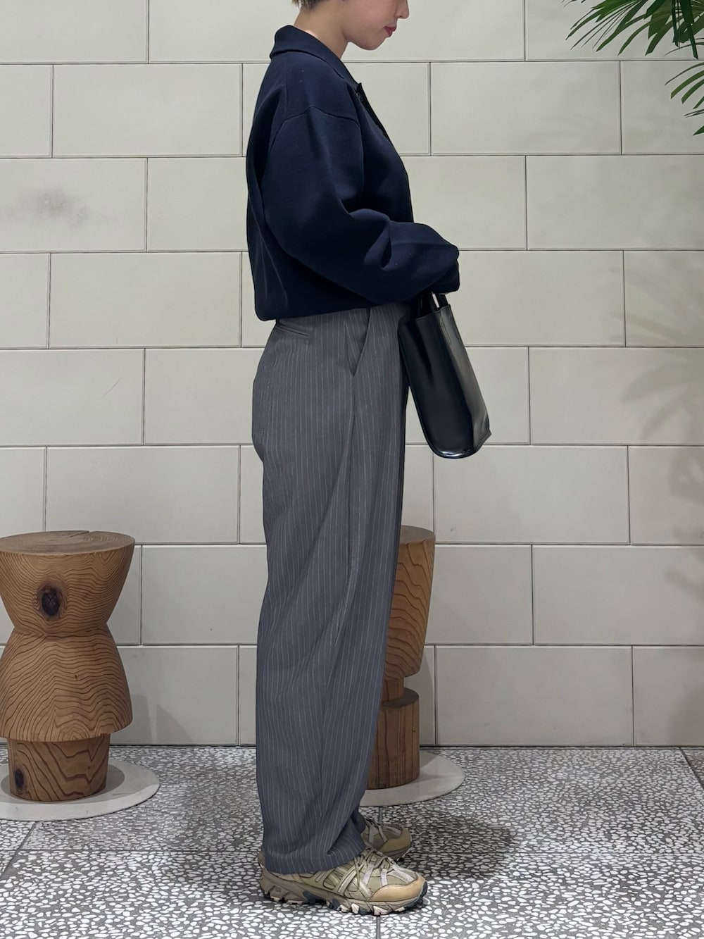 ブルー系のニット/セーター、グレー系のその他パンツ、ブラック系のトートバッグを着用したレディースの冬コーディネートの2枚目の写真