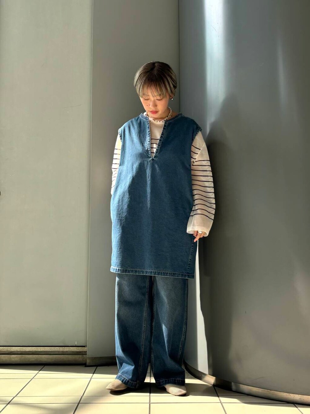 ホワイト系のその他シューズ、ブルー系のデニムパンツ、ホワイト系のニット/セーターを着用したレディースの夏コーディネートの2枚目の写真