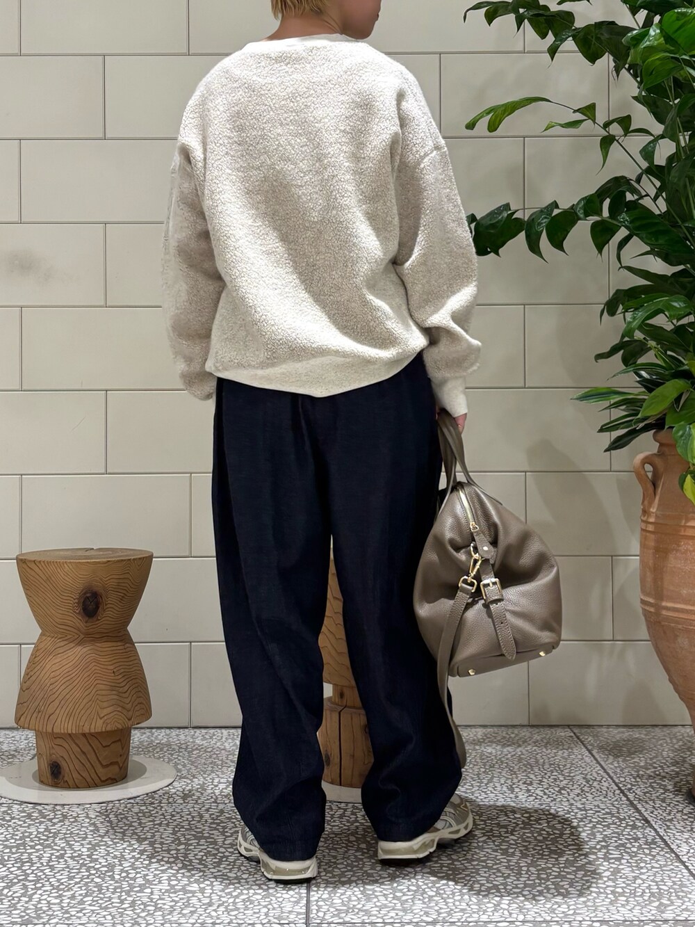 ベージュ系のボストンバッグ、ベージュ系のTシャツ/カットソー、ホワイト系のスニーカーを着用したレディースの秋コーディネートの2枚目の写真