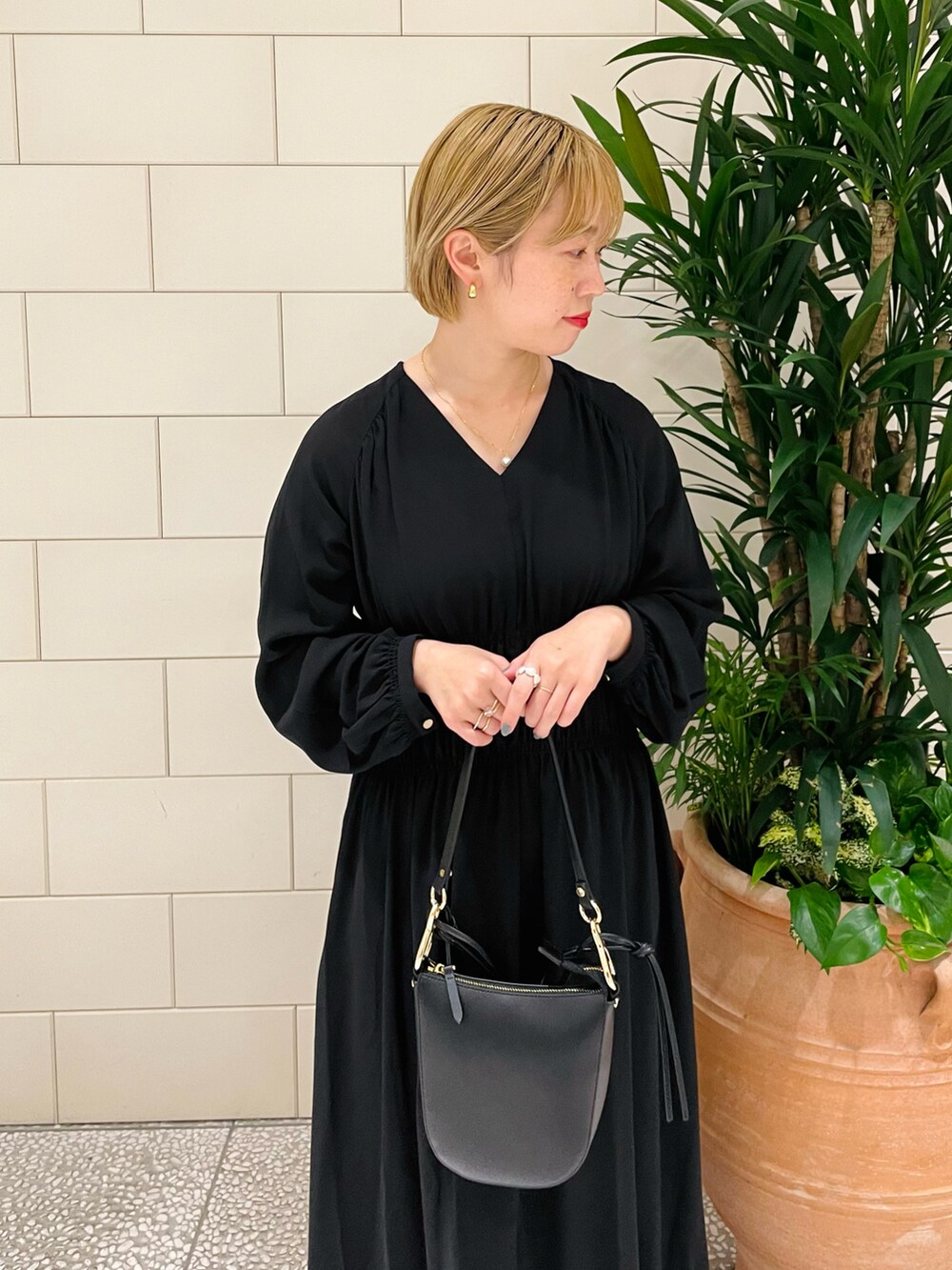 ブラック系のショルダーバッグ、ブラック系のワンピース、ブラック系のパンプスを着用したレディースの春コーディネートの3枚目の写真