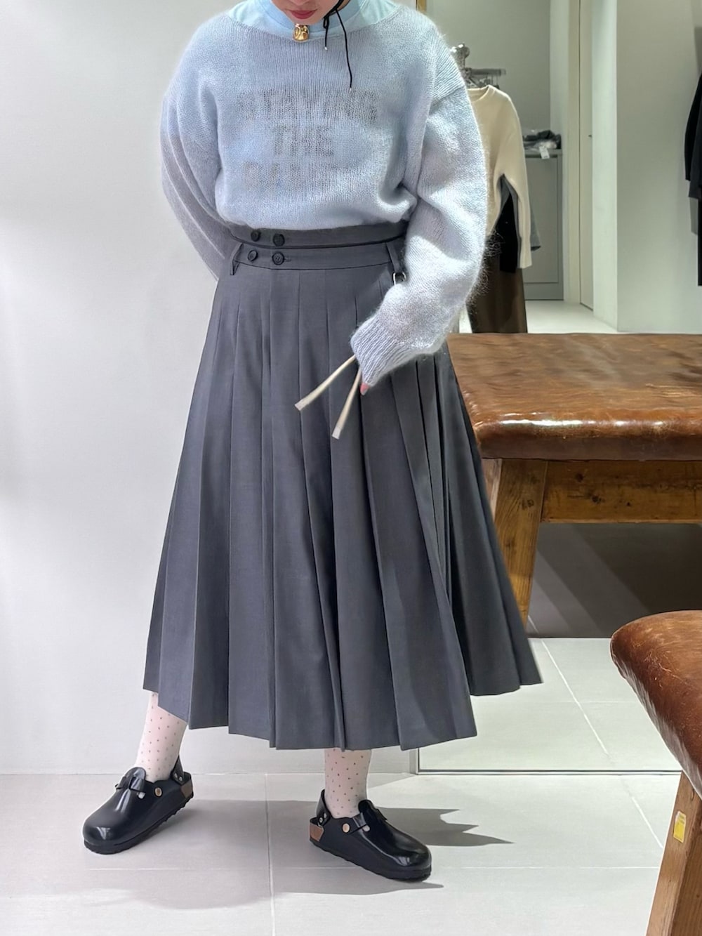 ブルー系のニット/セーター、ブルー系のTシャツ/カットソー、グリーン系のスカートを着用したレディースの秋コーディネートの2枚目の写真