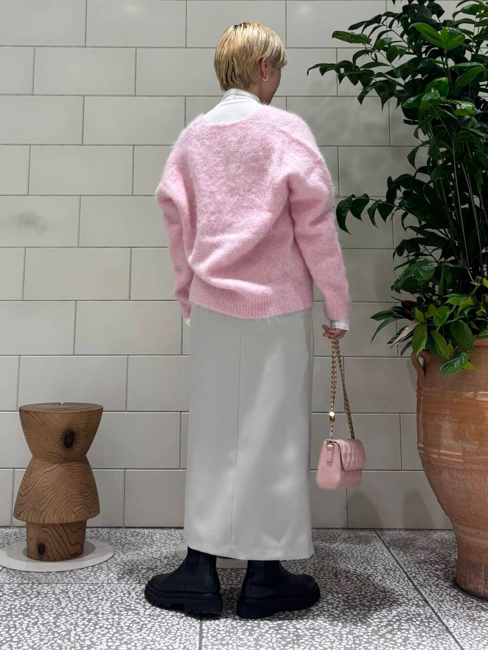 ピンク系のショルダーバッグ、ホワイト系のTシャツ/カットソー、ピンク系のニット/セーターを着用したレディースの秋コーディネートの3枚目の写真