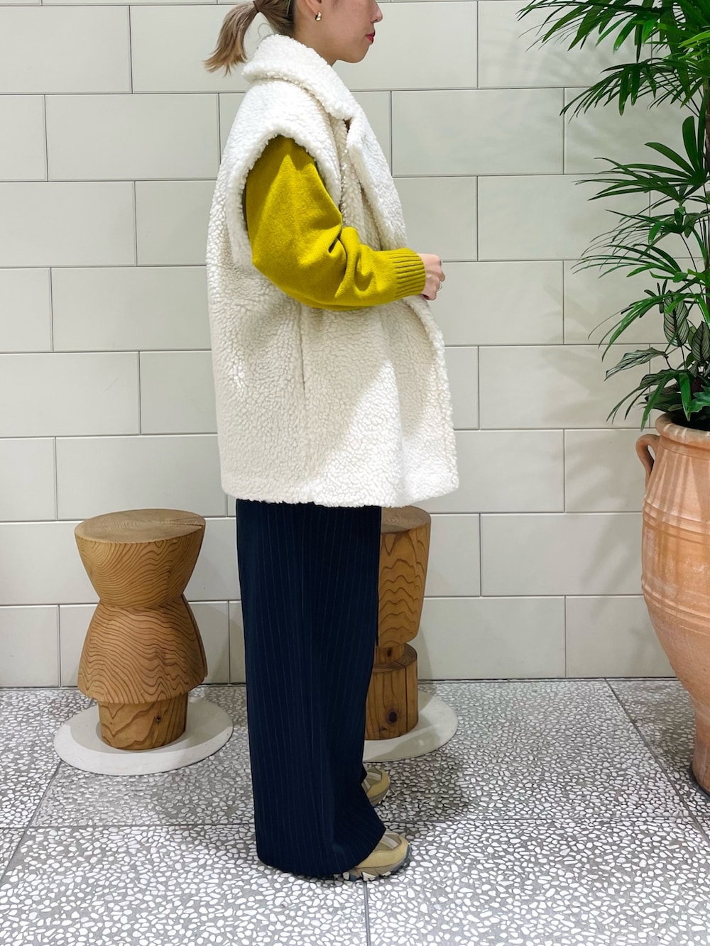 イエロー系のカーディガン/ボレロ、ホワイト系のその他アウター、ブルー系のその他パンツを着用したレディースの冬コーディネートの2枚目の写真