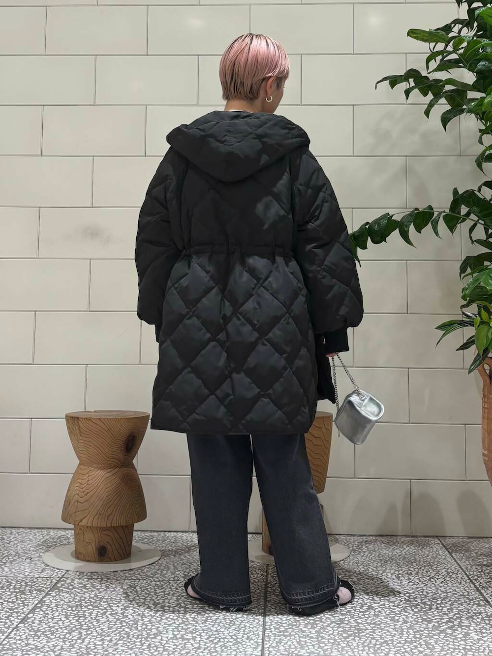 ブラック系のデニムパンツ、ピンク系のニット/セーター、シルバー系のショルダーバッグを着用したレディースの冬コーディネートの3枚目の写真