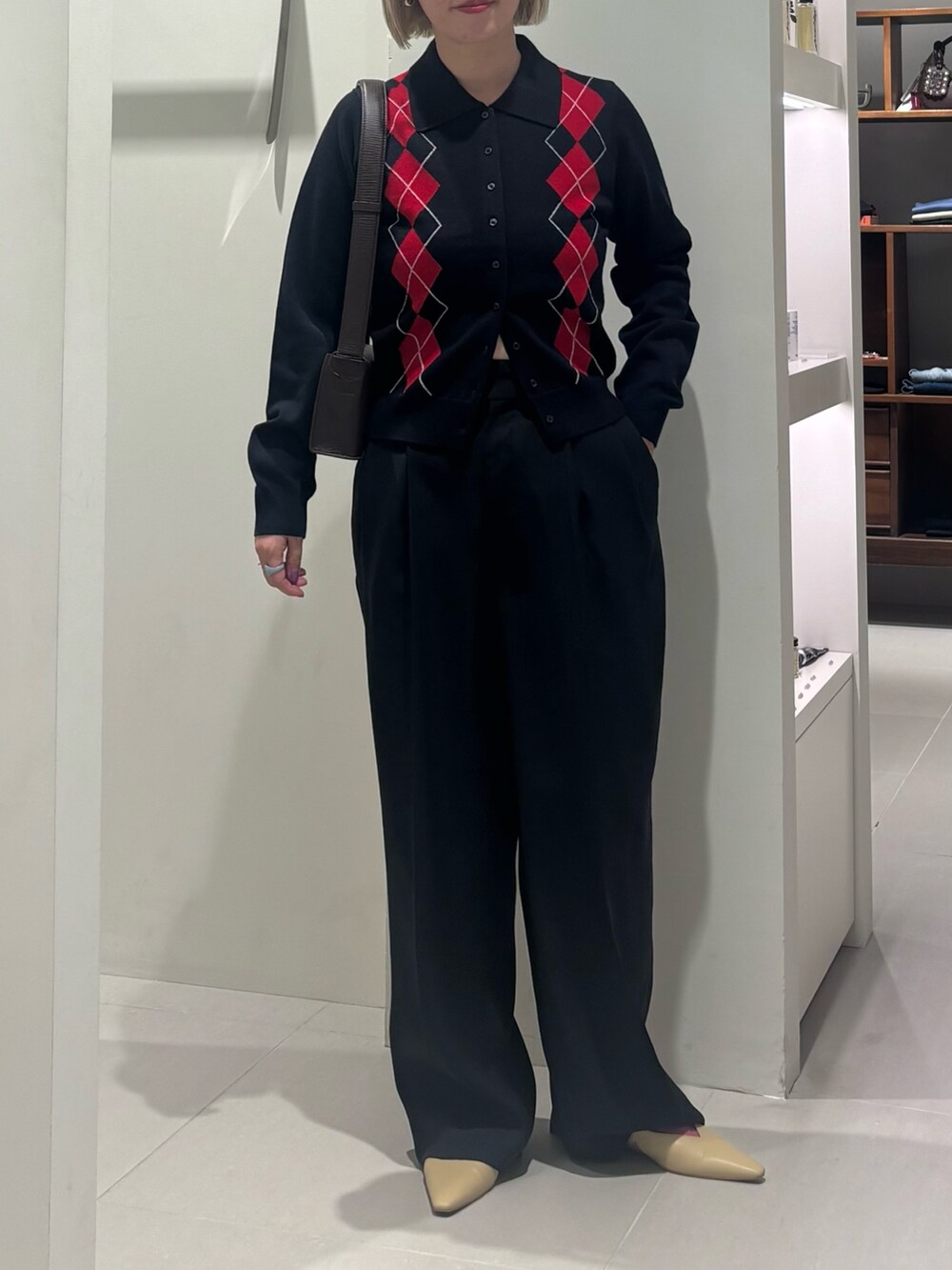 ブルー系のニット/セーター、ブラウン系のハンドバッグ、ブラック系のその他パンツを着用したレディースの秋コーディネートの3枚目の写真