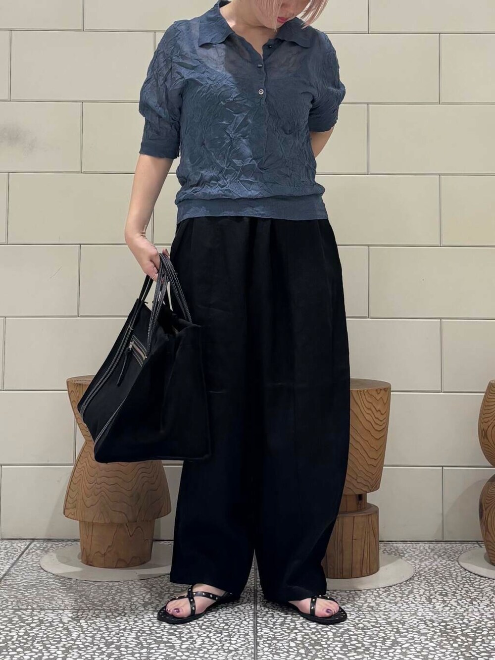 グレー系のニット/セーター、ブラック系のサンダルを着用したレディースの春コーディネートの2枚目の写真