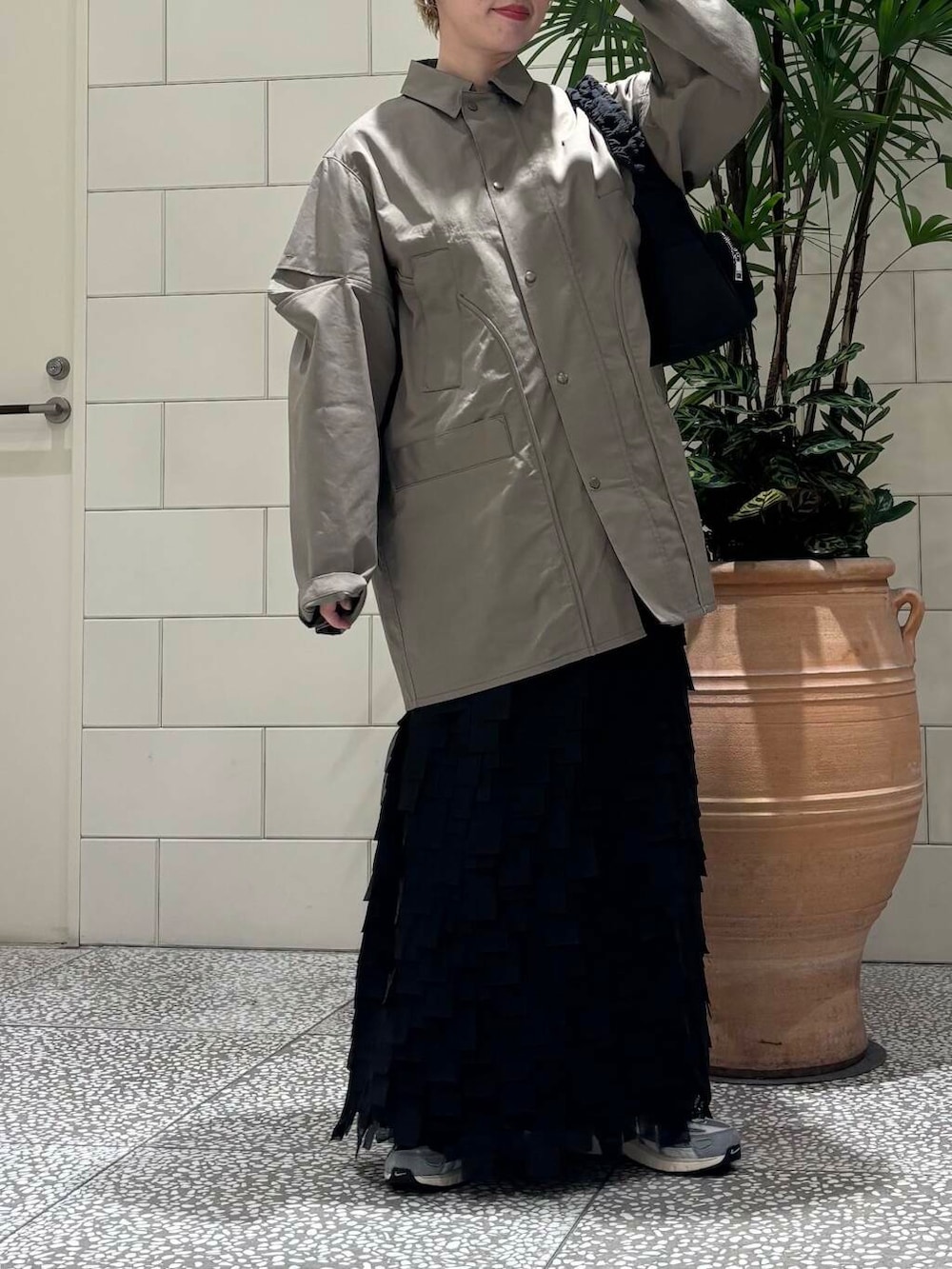 ホワイト系のスニーカー、ブラック系のショルダーバッグを着用したレディースの冬コーディネートの2枚目の写真