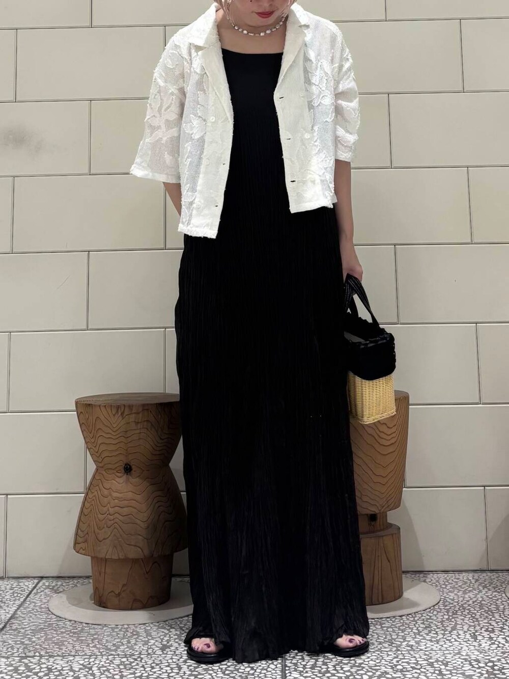 ブラック系のワンピース、ホワイト系のシャツ/ブラウス、ブラック系のサンダルを着用したレディースの春コーディネートの2枚目の写真