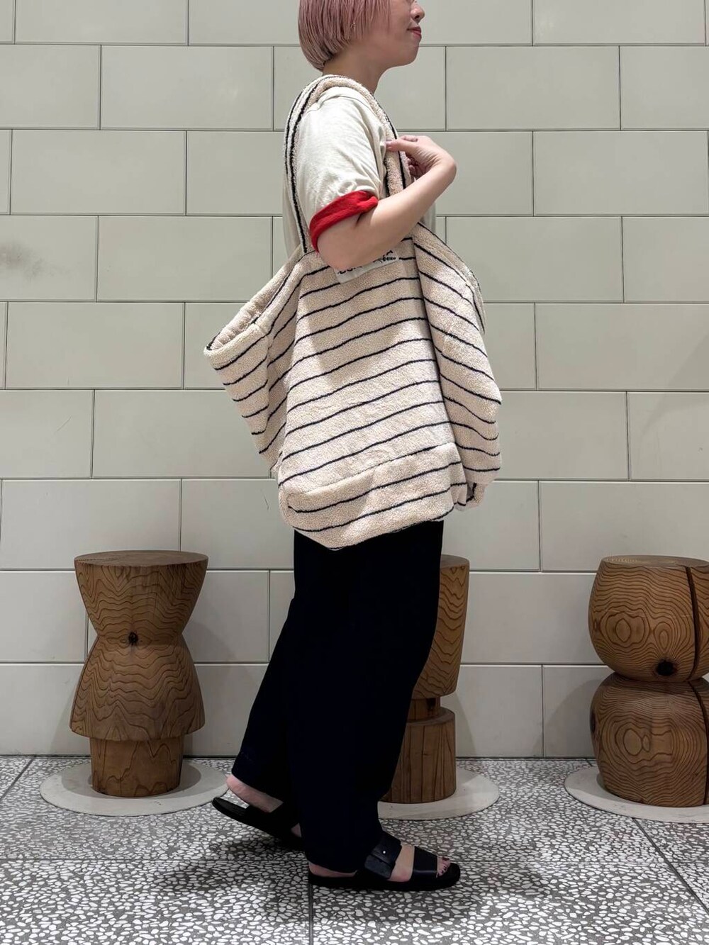 ブルー系のデニムパンツ、ブラック系のサンダル、レッド系のTシャツ/カットソーを着用したレディースの春コーディネートの2枚目の写真