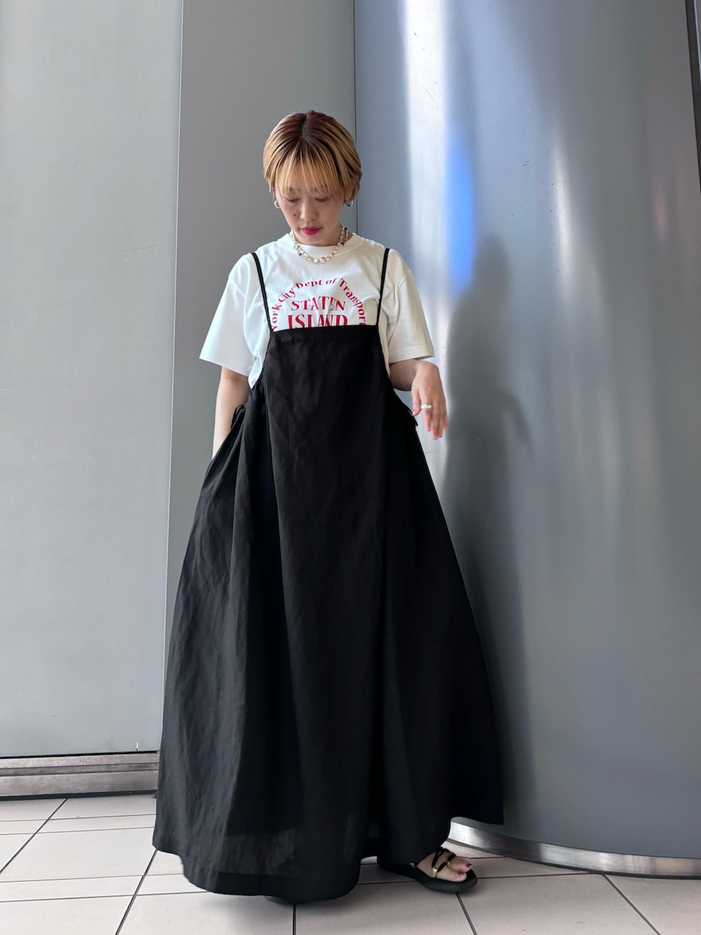 ブラック系のワンピース、ホワイト系のTシャツ/カットソー、グリーン系のパンツを着用したレディースの春コーディネートの2枚目の写真