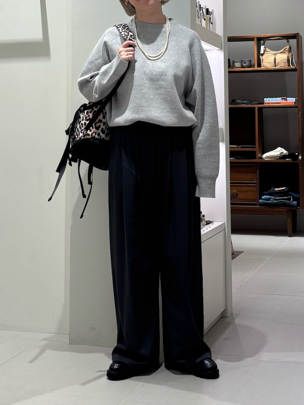 グレー系のニット/セーター、グレー系のその他パンツ、その他のバックパック/リュックを着用したレディースの秋コーディネートの3枚目の写真