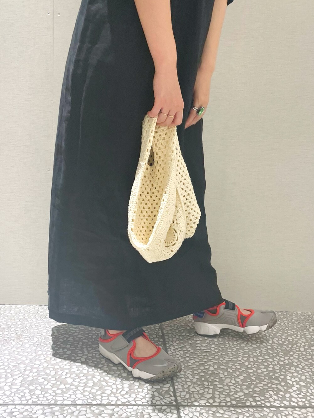 ブラック系のワンピース、ホワイト系のショルダーバッグ、グレー系のスニーカーを着用したレディースの春コーディネートの4枚目の写真