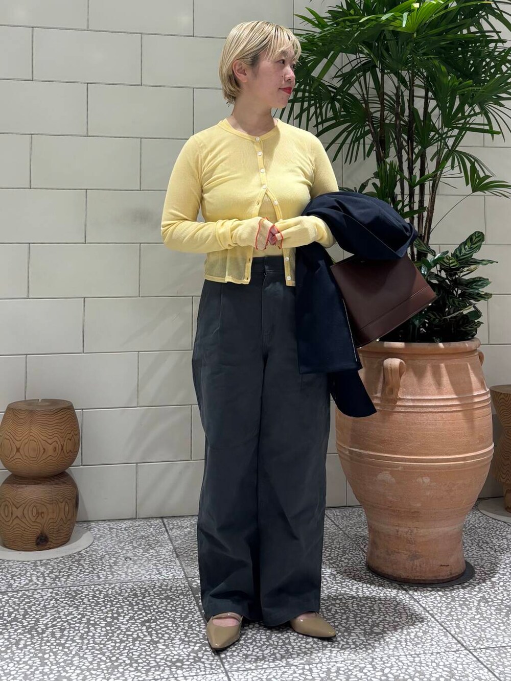 ブルー系のその他アウター、グレー系のその他パンツ、ブラウン系のハンドバッグを着用したレディースの冬コーディネートの4枚目の写真