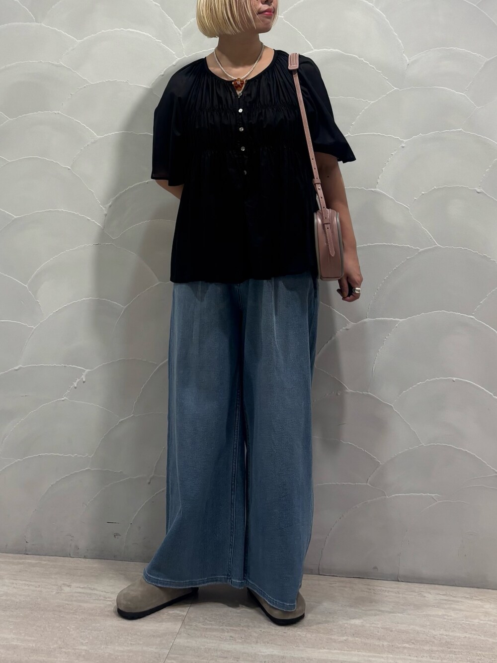 ピンク系のショルダーバッグ、ブルー系のデニムパンツ、ブラック系のシャツ/ブラウスを着用したレディースの夏コーディネートの3枚目の写真
