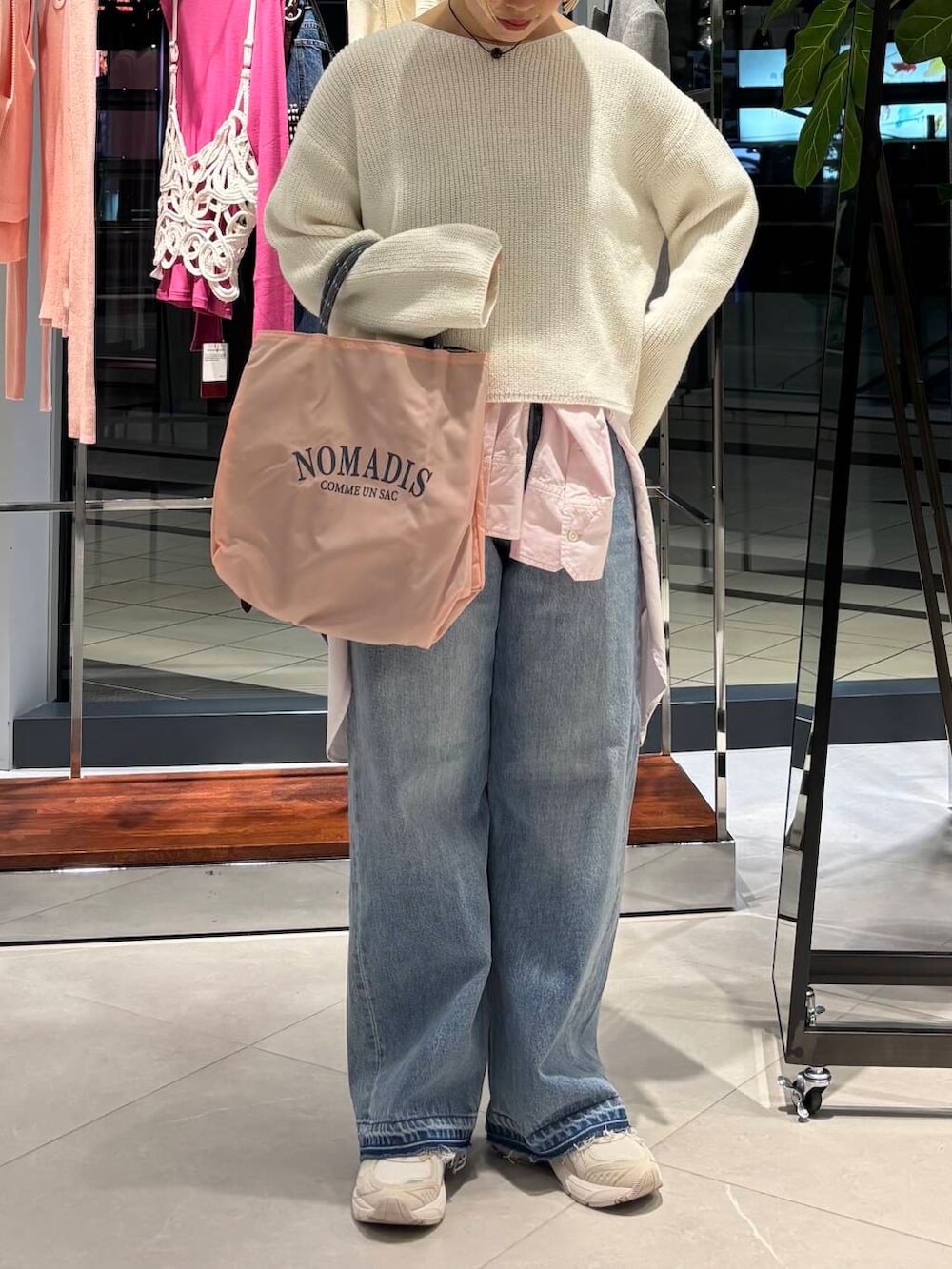 ブルー系のデニムパンツ、ピンク系のシャツ/ブラウス、ホワイト系のニット/セーターを着用したレディースの冬コーディネートの3枚目の写真