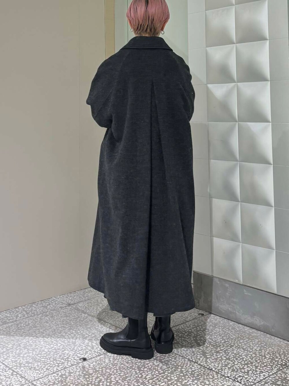 ブラック系のステンカラーコート、グレー系のスカート、グレー系のカーディガン/ボレロを着用したレディースの冬コーディネートの4枚目の写真