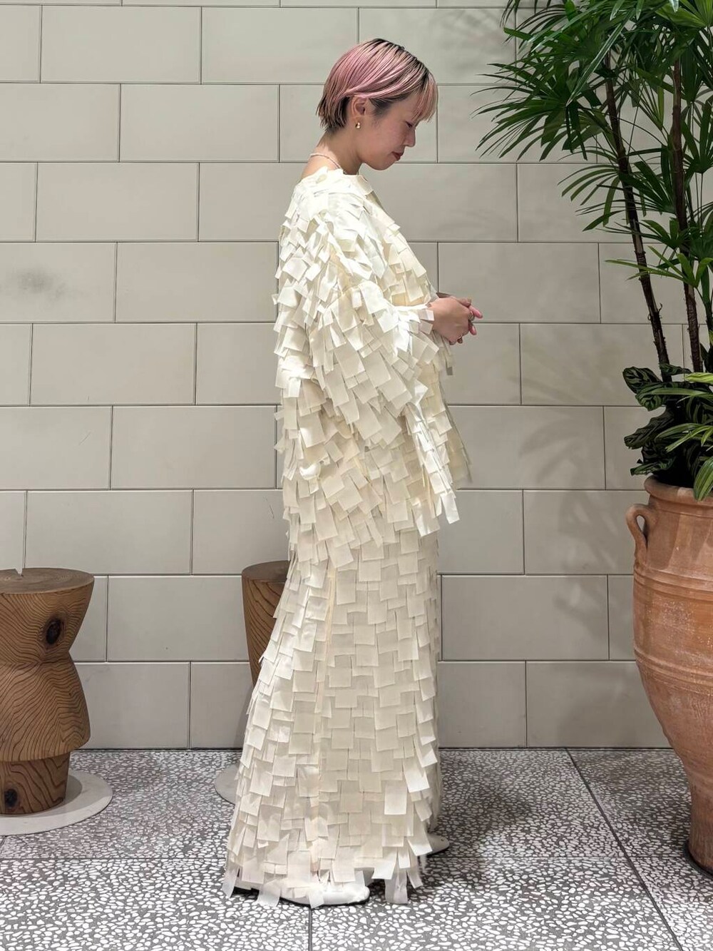 ホワイト系のパンプス、ホワイト系のテーラードジャケット、ベージュ系のスカートを着用したレディースの冬コーディネートの2枚目の写真