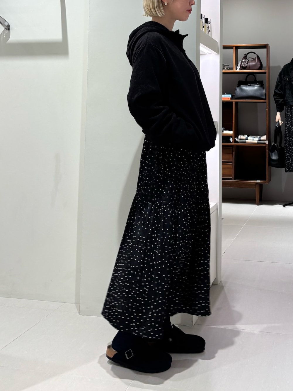 ブラック系のパーカー、ブラック系のワンピース、ブラック系のサンダルを着用したレディースの秋コーディネートの2枚目の写真