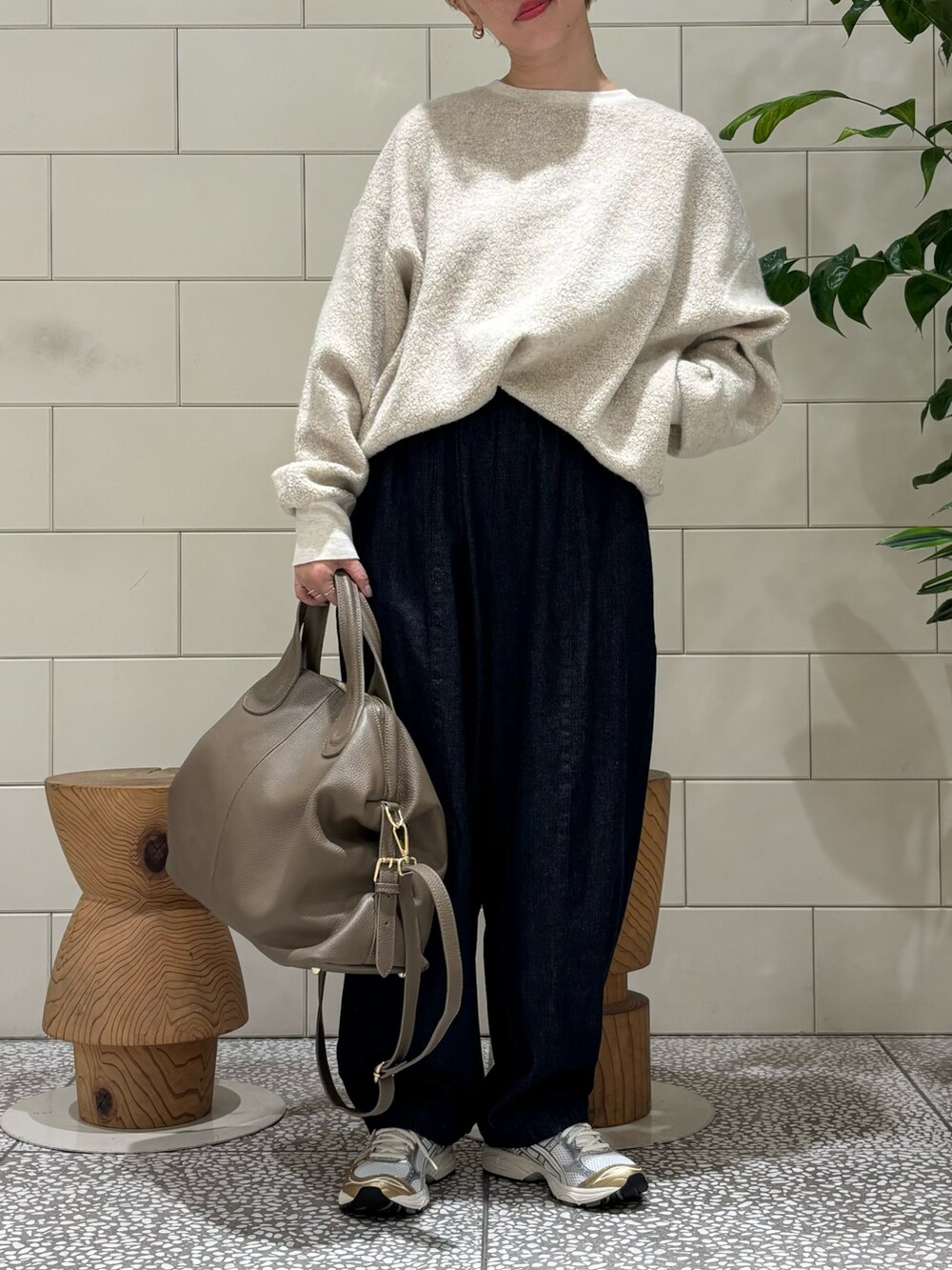 ベージュ系のボストンバッグ、ベージュ系のTシャツ/カットソー、ホワイト系のスニーカーを着用したレディースの秋コーディネートの3枚目の写真