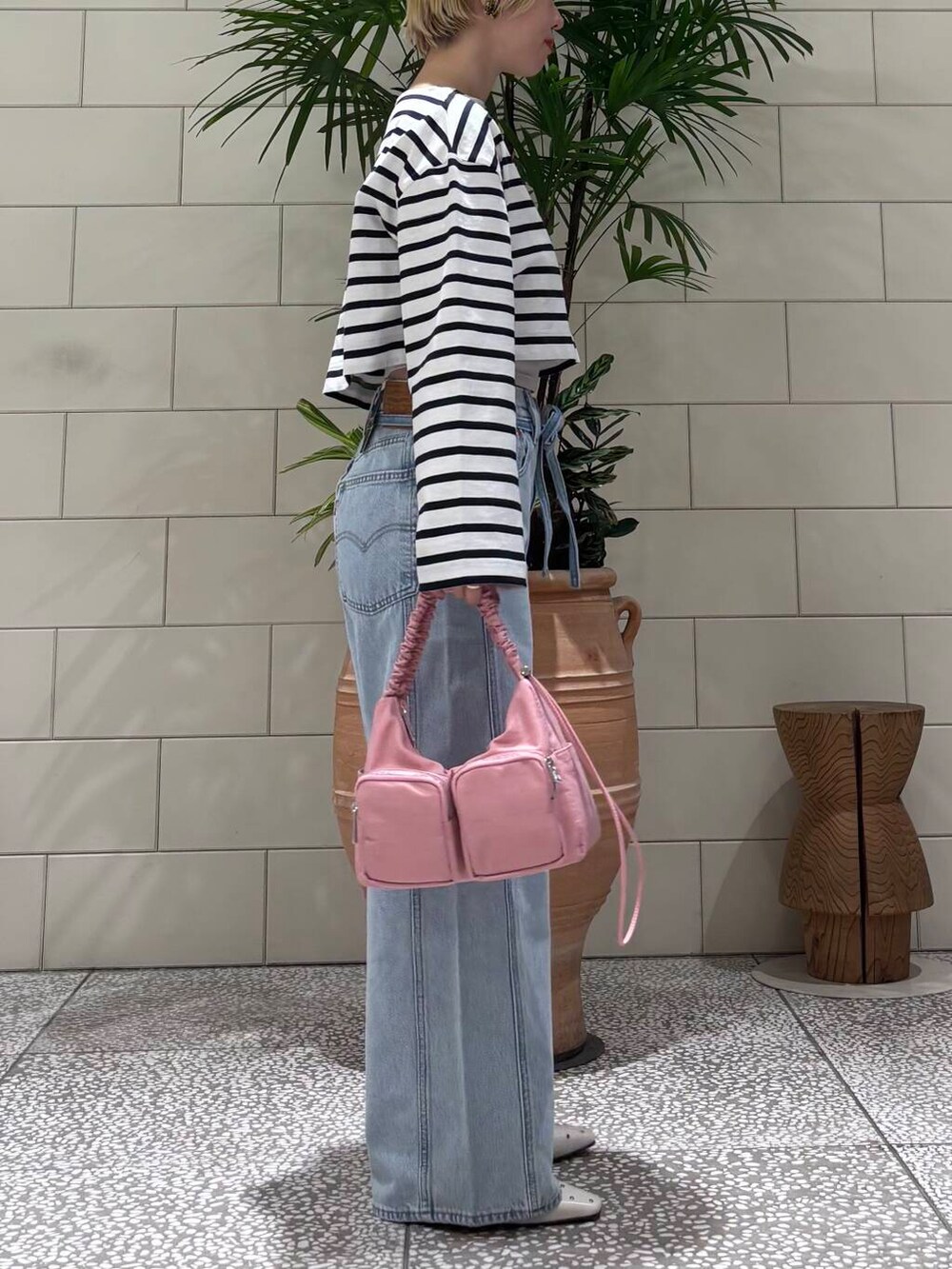 レッド系のショルダーバッグ、ホワイト系のパンプス、ブルー系のTシャツ/カットソーを着用したレディースの冬コーディネートの2枚目の写真