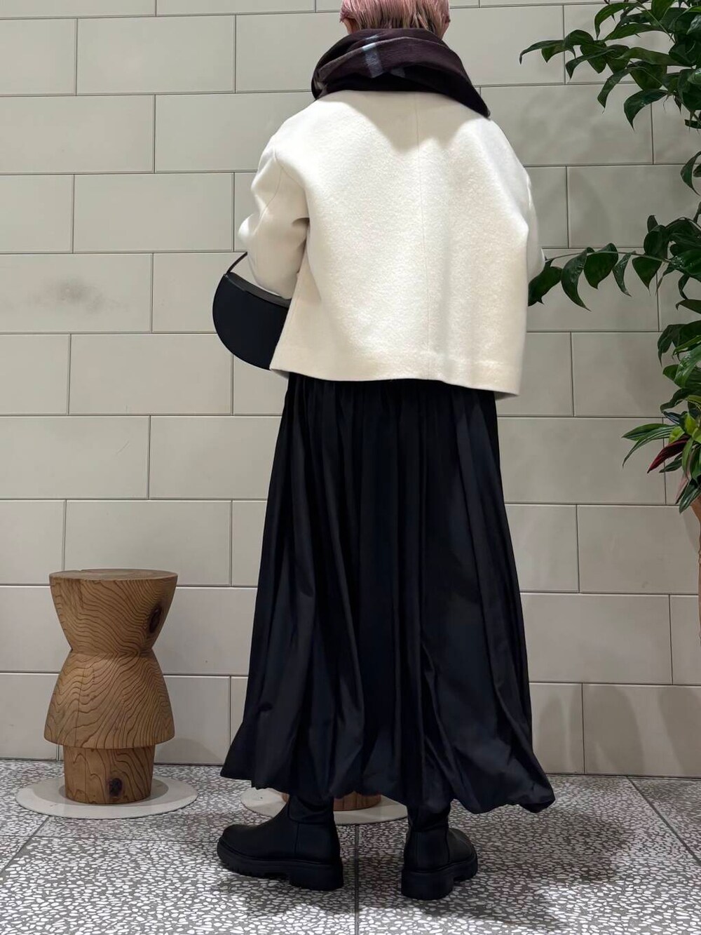 ブラック系のブーツ、ホワイト系のその他アウター、ブラック系のワンピースを着用したレディースの冬コーディネートの3枚目の写真