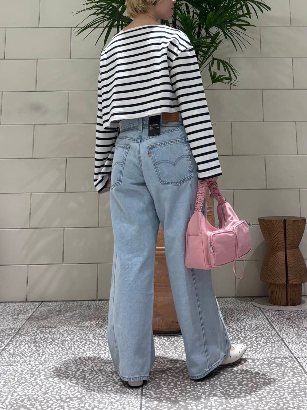 レッド系のショルダーバッグ、ホワイト系のパンプス、ブルー系のTシャツ/カットソーを着用したレディースの冬コーディネートの3枚目の写真