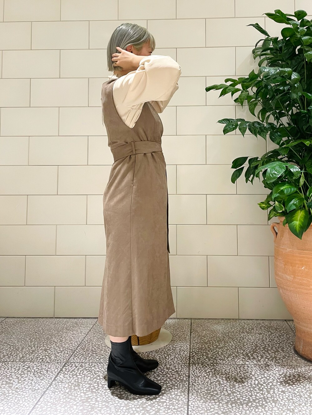 ブラウン系のワンピース、ホワイト系のシャツ/ブラウス、ブラック系のブーツを着用したレディースの秋コーディネートの2枚目の写真