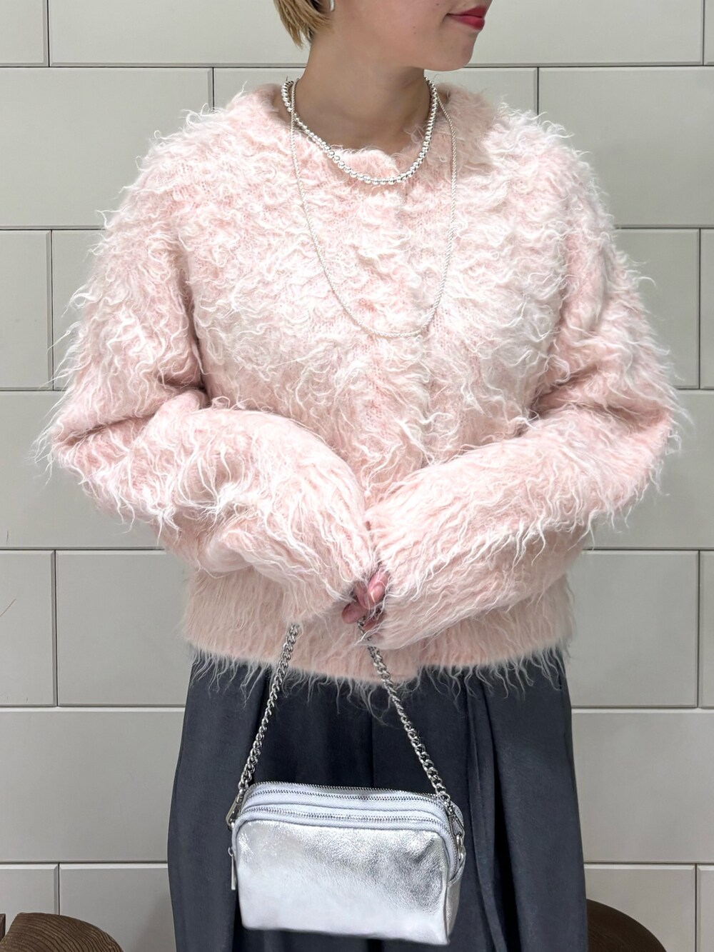 グレー系のその他パンツ、ピンク系のカーディガン/ボレロ、シルバー系のショルダーバッグを着用したレディースの秋コーディネートの3枚目の写真