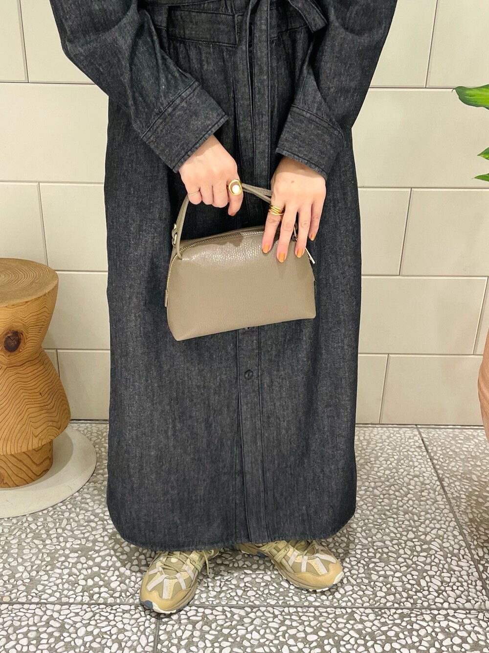 ブラック系のワンピース、ベージュ系のボストンバッグ、グリーン系のスニーカーを着用したレディースの夏コーディネートの3枚目の写真