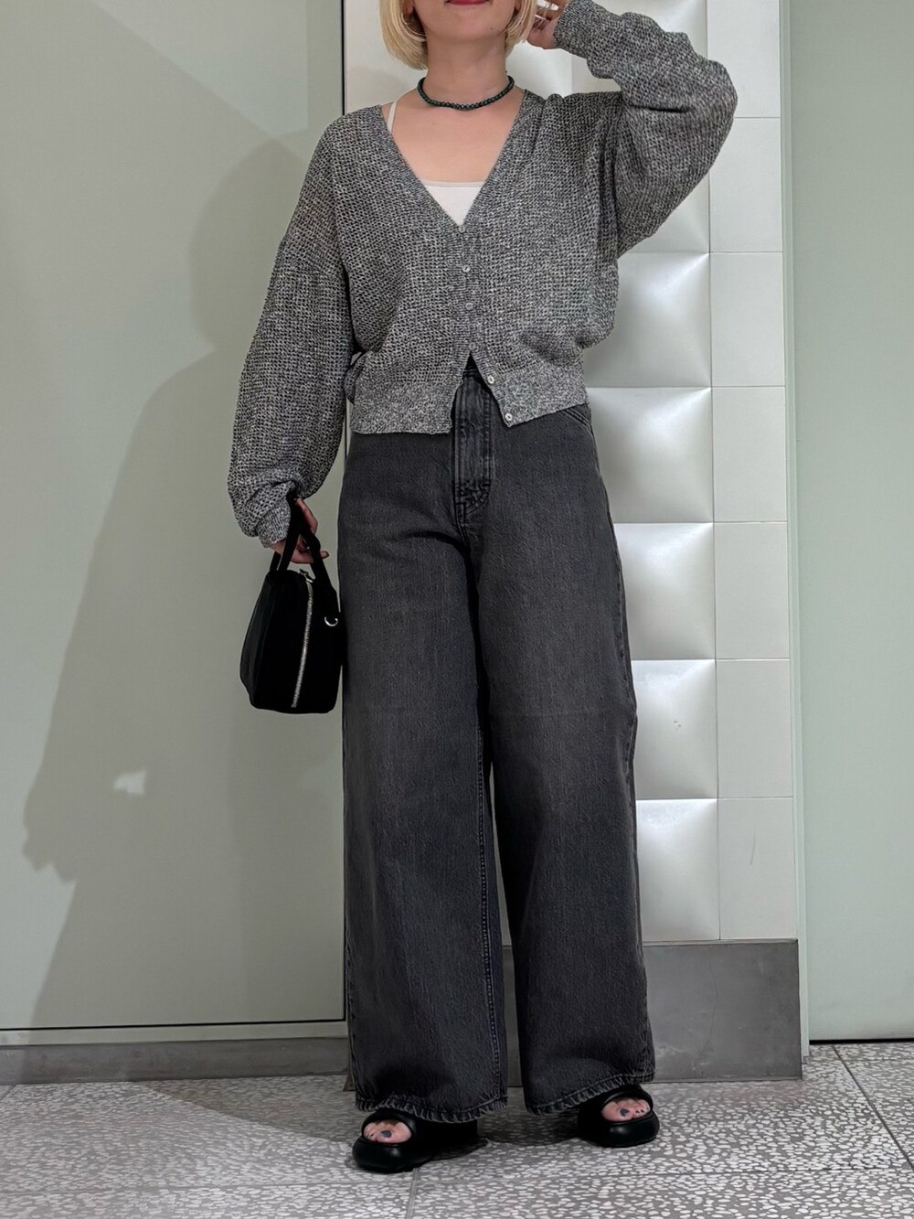 ブラック系のカーディガン/ボレロ、ブラック系のボストンバッグ、ブラック系のデニムパンツを着用したレディースの夏コーディネートの2枚目の写真