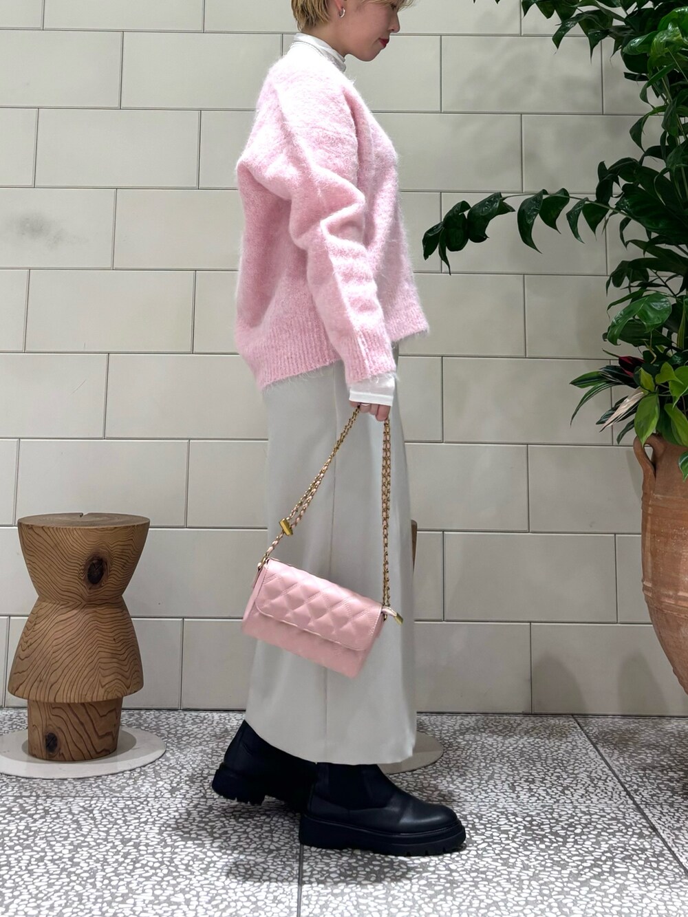 ピンク系のニット/セーター、ホワイト系のTシャツ/カットソー、ピンク系のショルダーバッグを着用したレディースの秋コーディネートの2枚目の写真