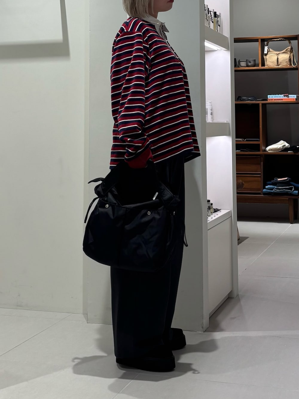 レッド系のTシャツ/カットソー、グレー系のその他パンツ、ブラック系のショルダーバッグを着用したレディースの秋コーディネートの3枚目の写真