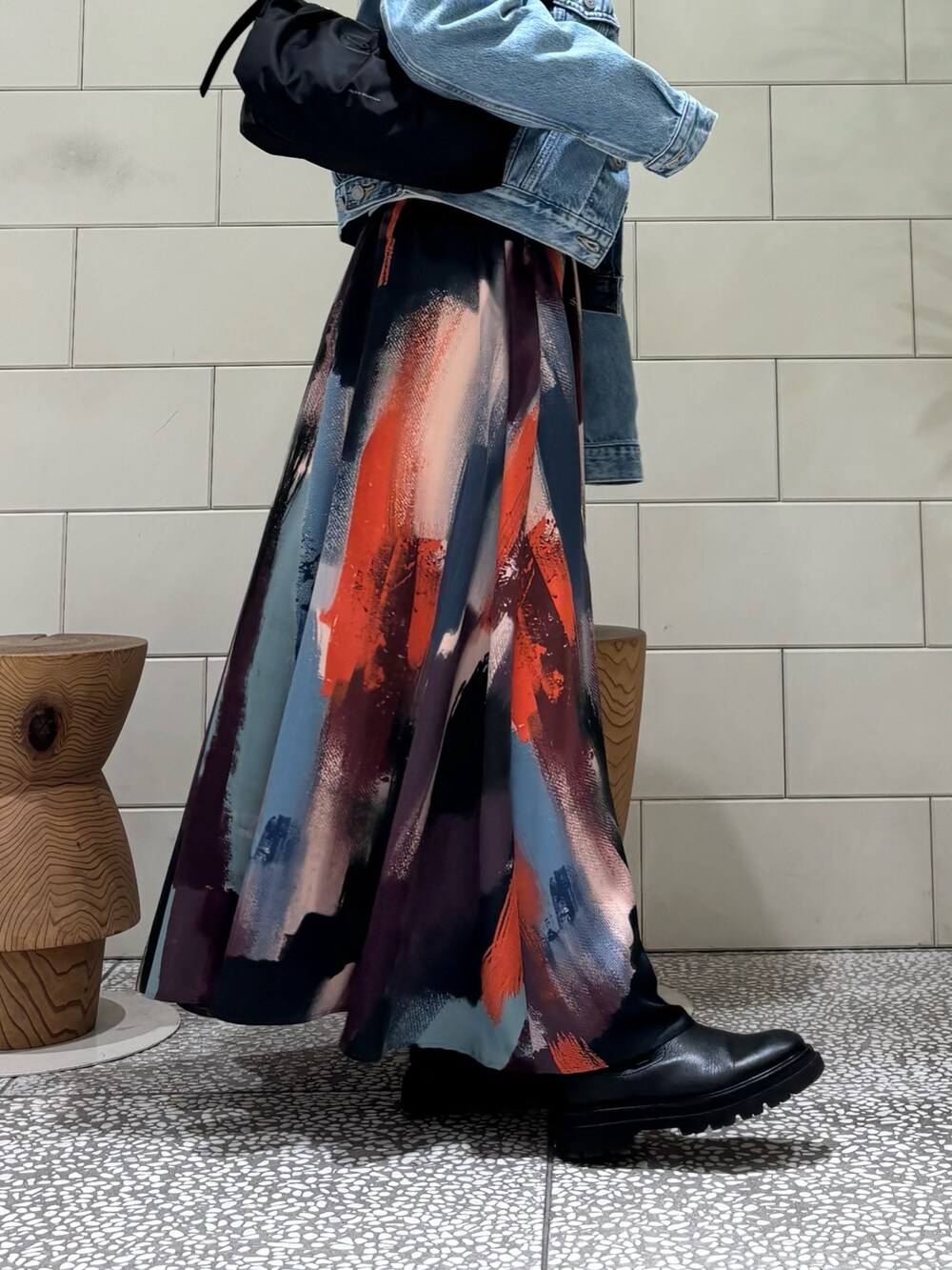 グレー系のスウェット、ピンク系のスカート、ブルー系のデニムジャケットを着用したレディースの冬コーディネートの3枚目の写真