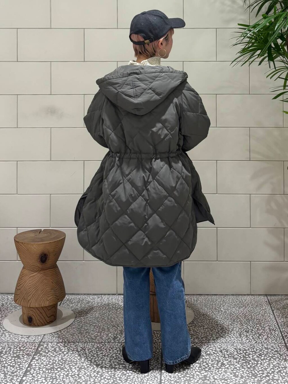 ブルー系のデニムパンツ、ベージュ系のショルダーバッグ、ホワイト系のニット/セーターを着用したレディースの冬コーディネートの4枚目の写真