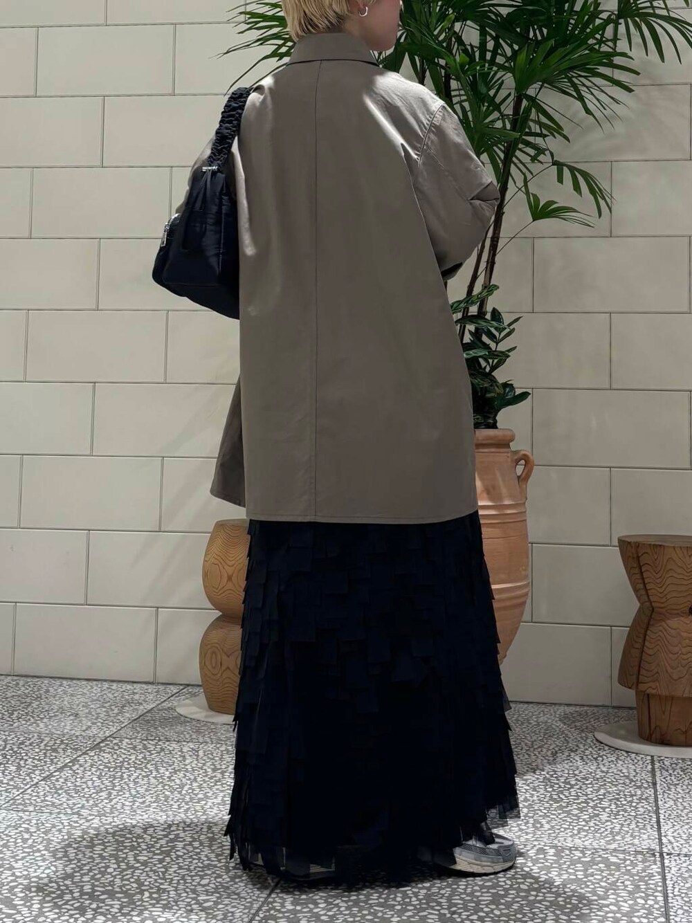 ホワイト系のスニーカー、ブラック系のショルダーバッグを着用したレディースの冬コーディネートの4枚目の写真