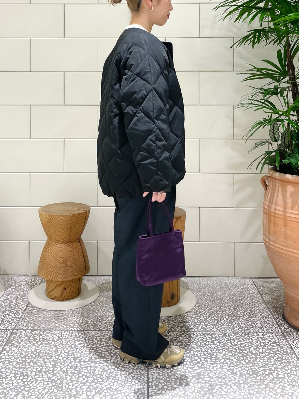 ブラック系のその他アウター、ホワイト系のカーディガン/ボレロ、ブラック系のその他パンツを着用したレディースの冬コーディネートの2枚目の写真