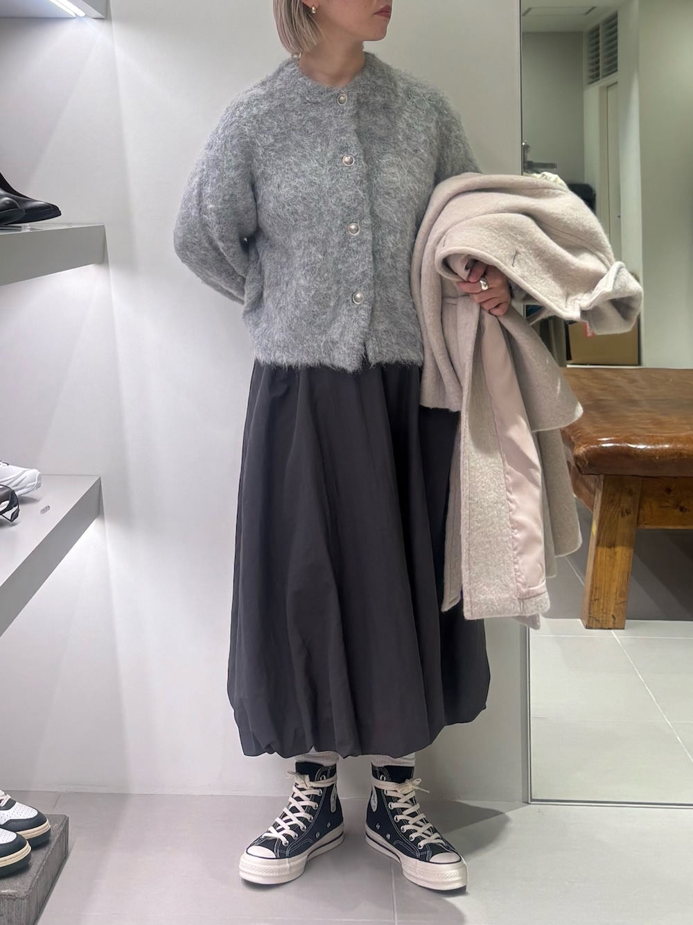 ホワイト系のテーラードジャケット、グレー系のカーディガン/ボレロ、グレー系のスカートを着用したレディースの秋コーディネートの3枚目の写真