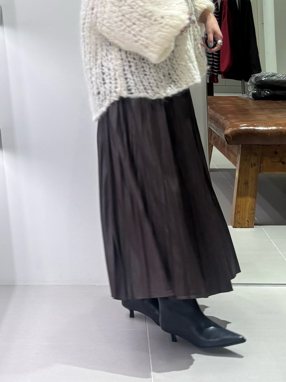 ホワイト系のニット/セーター、ブラウン系のトートバッグ、ブラウン系のスカートを着用したレディースの秋コーディネートの3枚目の写真